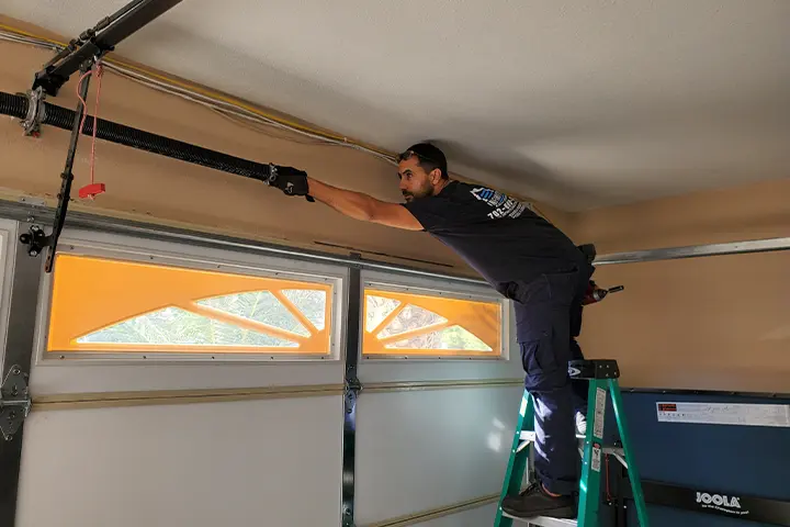 Technician inspecting a garage door for wear and tear in Las Vegas.