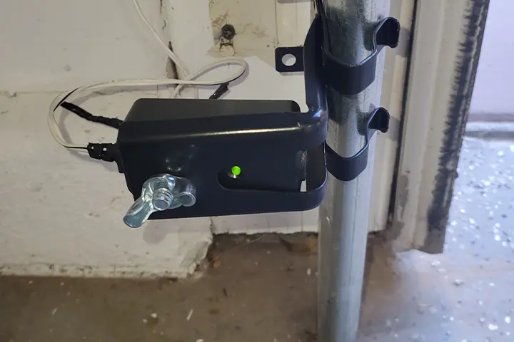 Technician checking the photo-eye sensors on a garage door