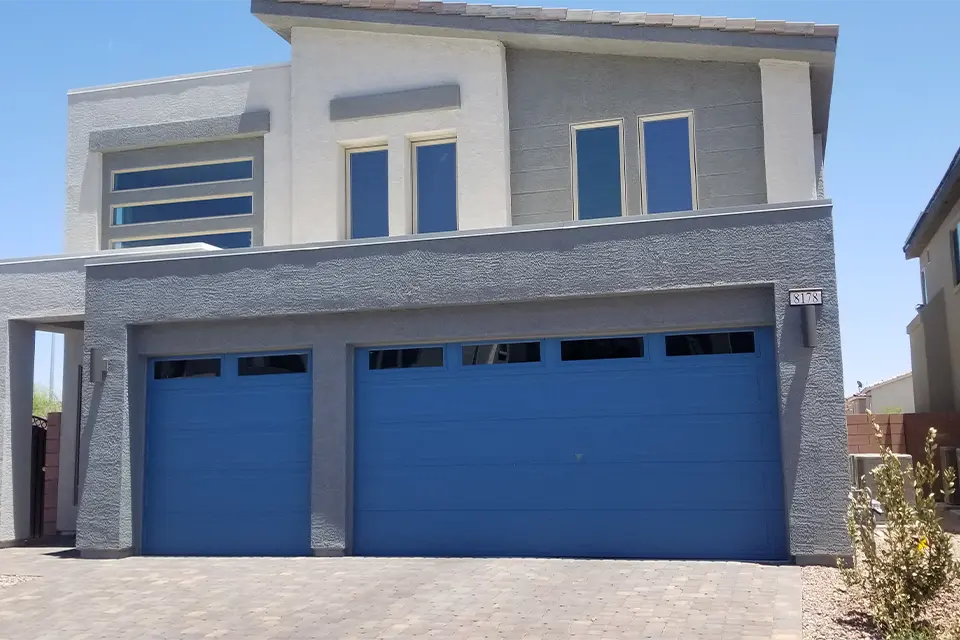 Traditional garage door with raised panels and decorative hardware.