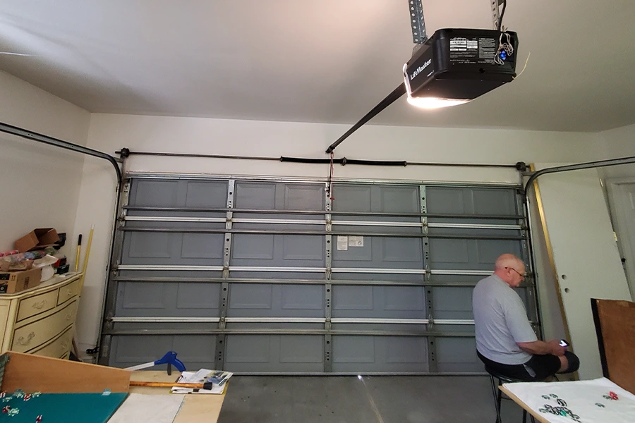 Homeowner inspecting garage door panels for damage