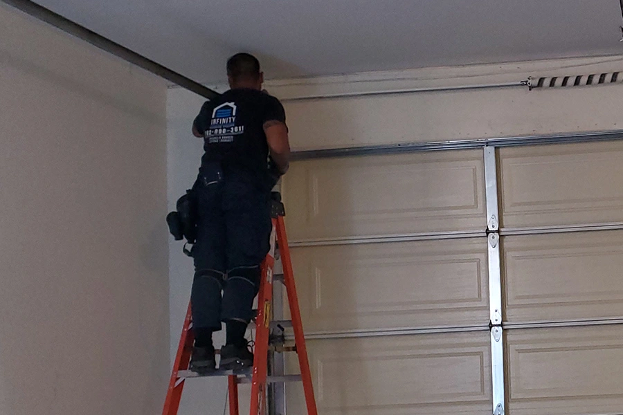 Garage door technician repairing cable