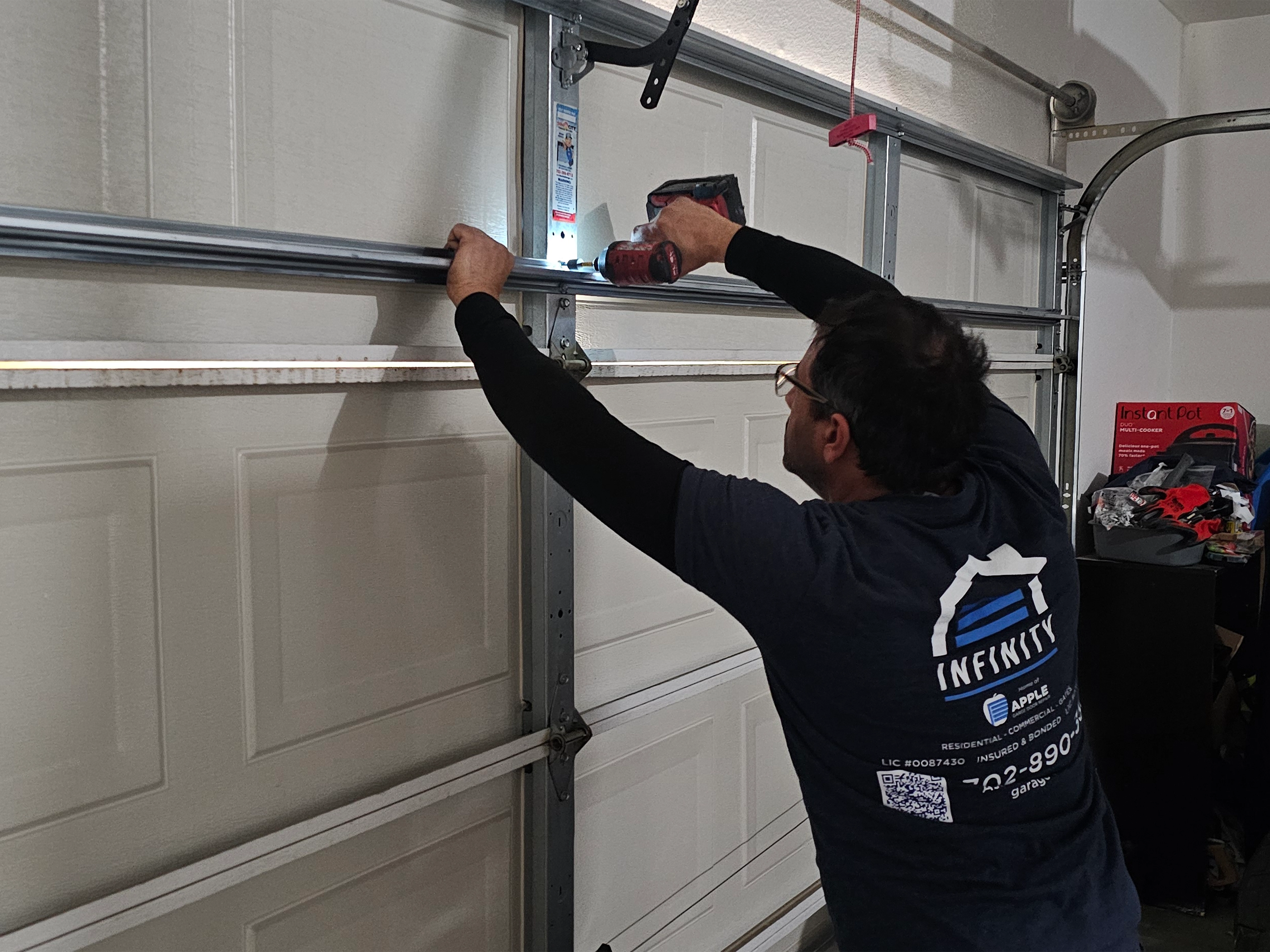 Infinity Garage Door Repair technician expertly servicing a garage door in Centennial Hills, NV, ensuring smooth 24/7 operation.